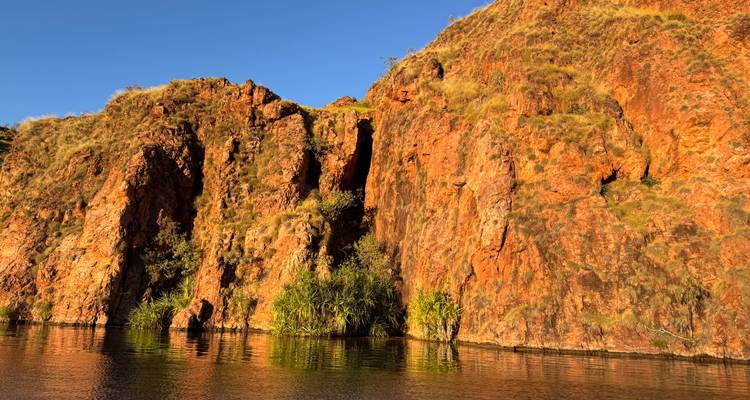 Orange cliffs reflecting in water.