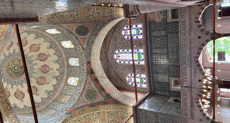 Intérieur décoré d'une mosquée avec vitraux et carreaux.