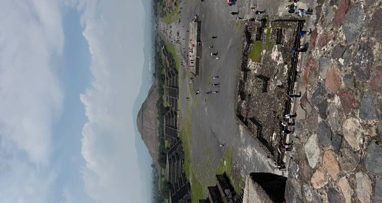 Vue grand angle d'un site archéologique ancien avec des pyramides et des touristes.