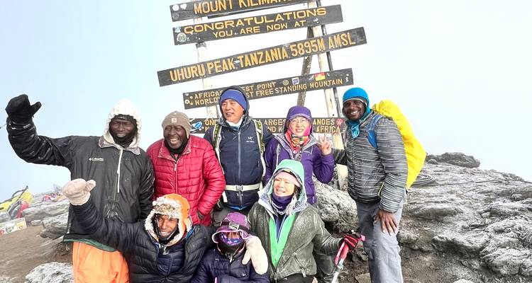 Un groupe de personnes célébrant au sommet du mont Kilimandjaro.