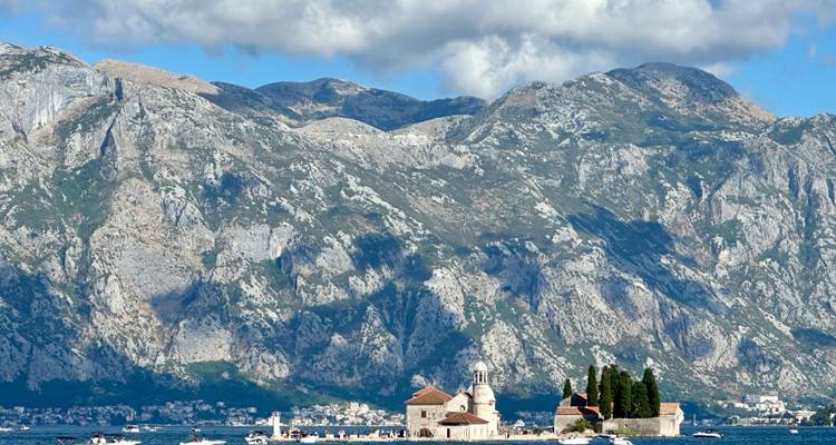 Île avec une église et des cyprès sur l'eau.