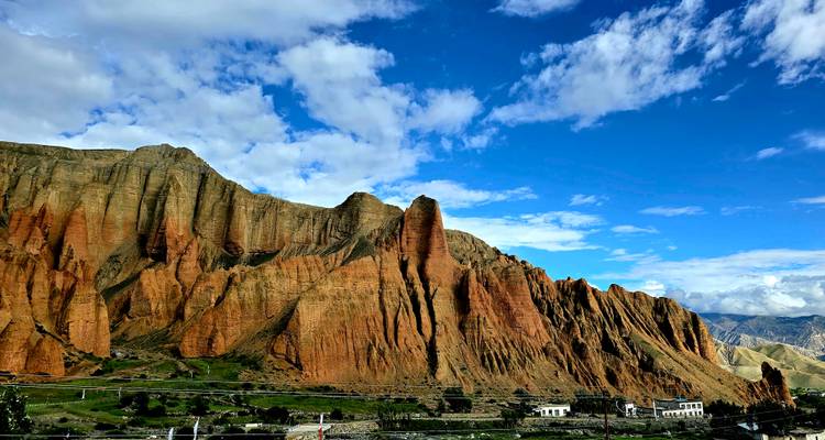 Distinctive red cliffs with a blue sky and few clouds.
