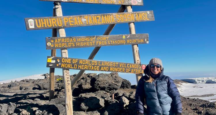 Touriste au panneau du sommet Uhuru sur le mont Kilimandjaro.