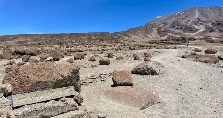 Paysage montagneux avec un panneau directionnel indiquant Kibo Hut et Horombo Hut.