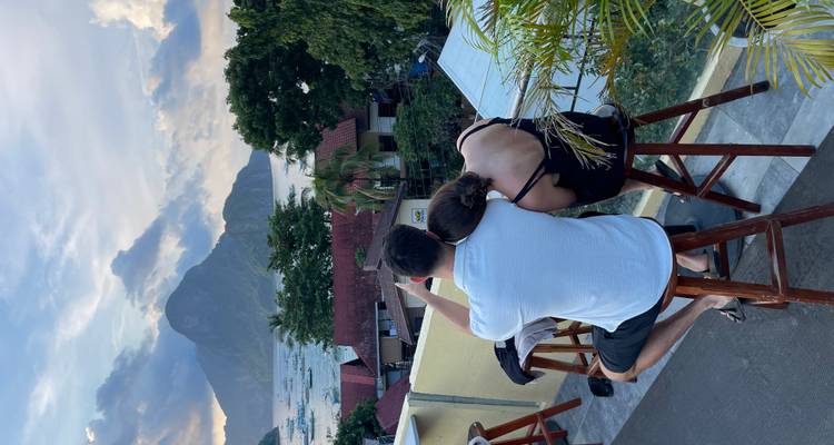 Couple enjoying a view of the bay and mountain from a terrace.