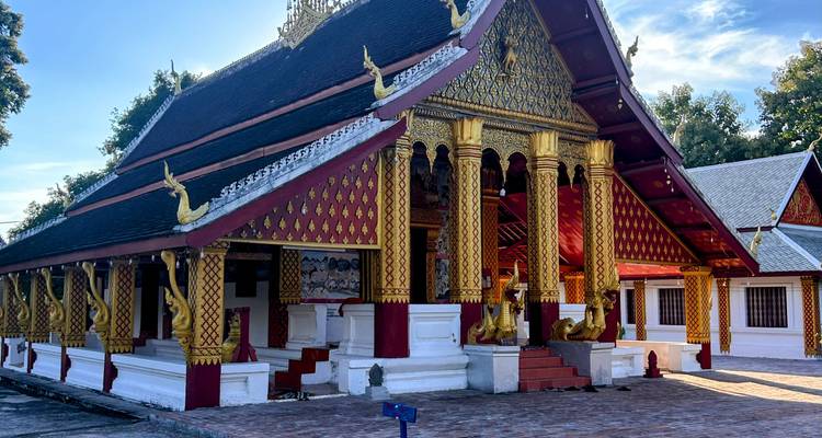 Temple au design orné avec des détails dorés et un ciel bleu.