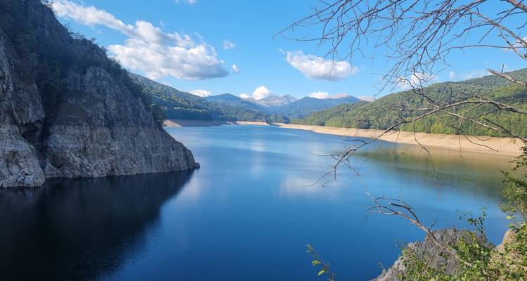 Vista panorámica de un lago tranquilo rodeado de montañas.