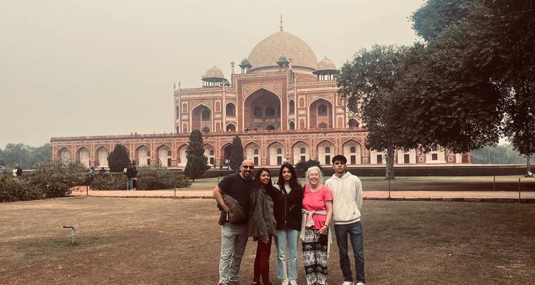 Groupe de personnes posant devant le tombeau d'Humayun par temps nuageux.