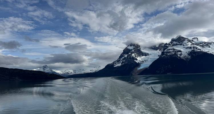 View from a boat cruising towards snow-capped mountains and glaciers.