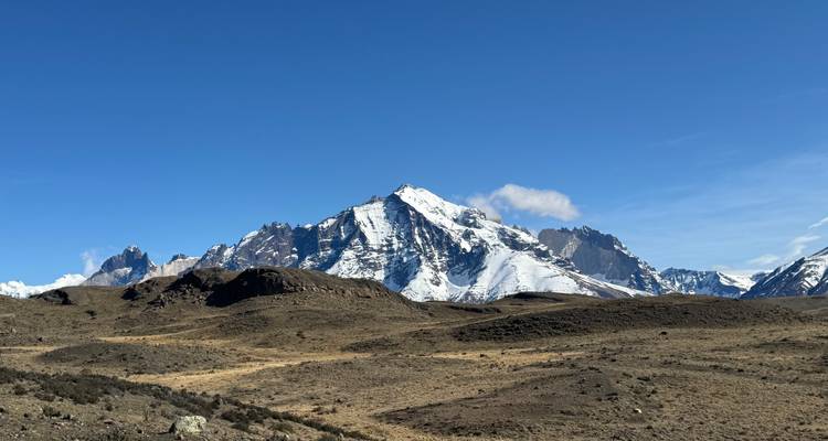 Expansive view of mountains with snow-covered peaks under a clear sky.
