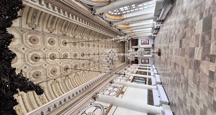 Elegant interior of a historic building with chandeliers and large windows.