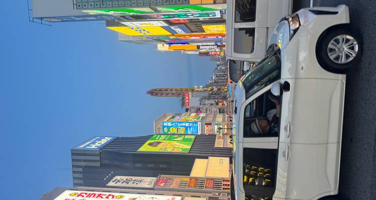 Rue animée de la ville au crépuscule avec des enseignes éclairées.