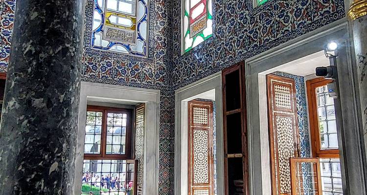 Interior of a building with ornate tiles and windows.