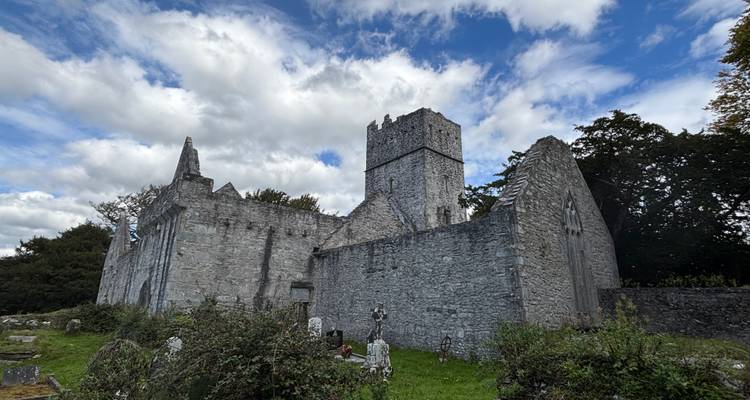 Ruines d'une ancienne église en pierre sous un ciel bleu.