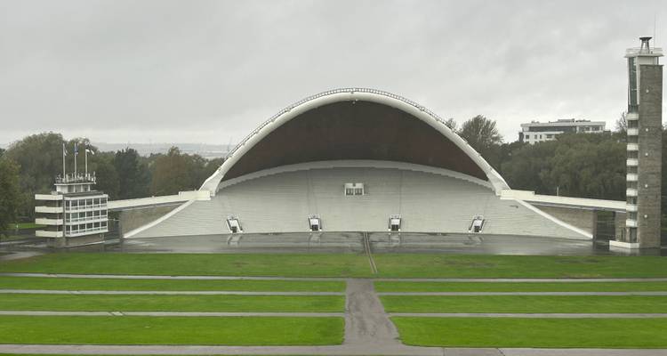 Large amphithéâtre avec un toit en arc dans un espace ouvert.