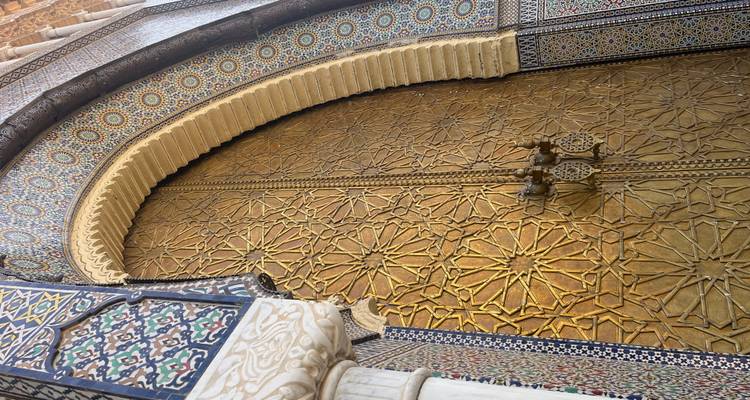 Une vue rapprochée d'une porte dorée au design orné.