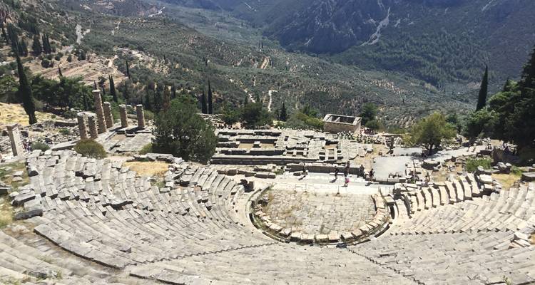 Ruines d'amphithéâtre antique situées dans une vallée verdoyante luxuriante.