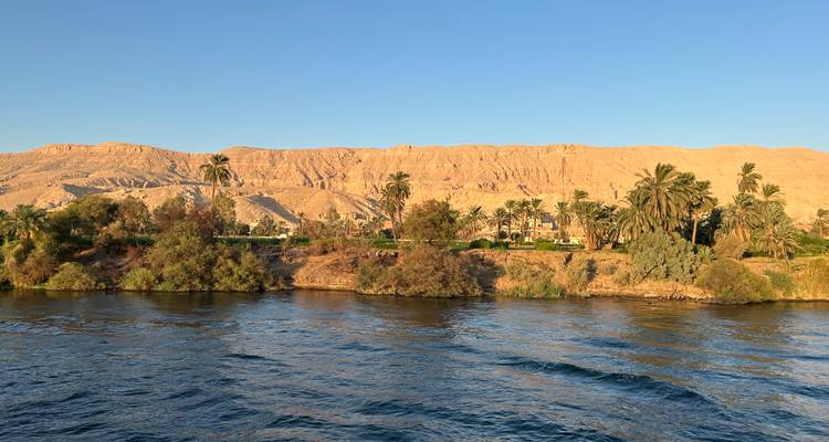 Berge avec palmiers et vue sur les collines de l'autre côté de l'eau.