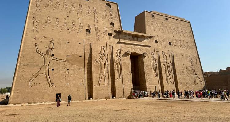 Façade d'un temple égyptien antique avec des hiéroglyphes et des gens.
