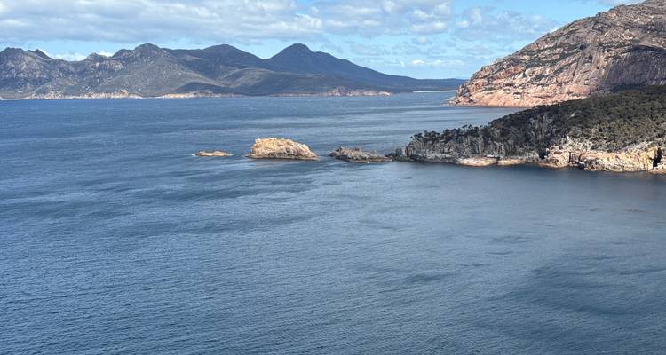 Coastal landscape with mountain range and ocean view.