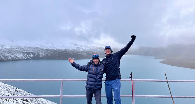 Deux randonneurs célébrant sur un point de vue avec un lac pittoresque et des montagnes.