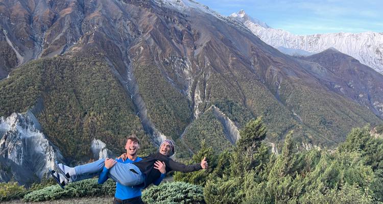 Deux personnes posant de manière ludique avec des montagnes spectaculaires en arrière-plan.