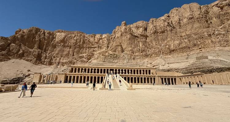 Visiteurs au Temple d'Hatchepsout avec toile de fond rocheuse.