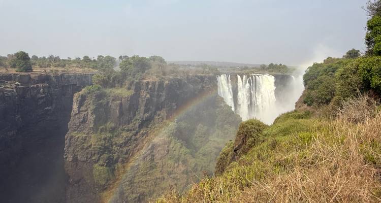 Cascade avec un arc-en-ciel se formant à travers la gorge.