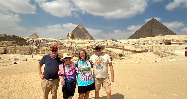 Groupe posant devant les Grandes Pyramides et le Sphinx de Gizeh.