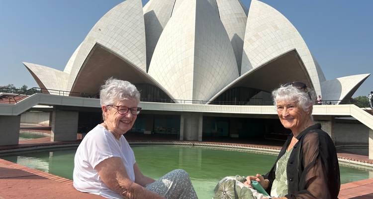 Femmes assises devant le Temple du Lotus, souriantes.