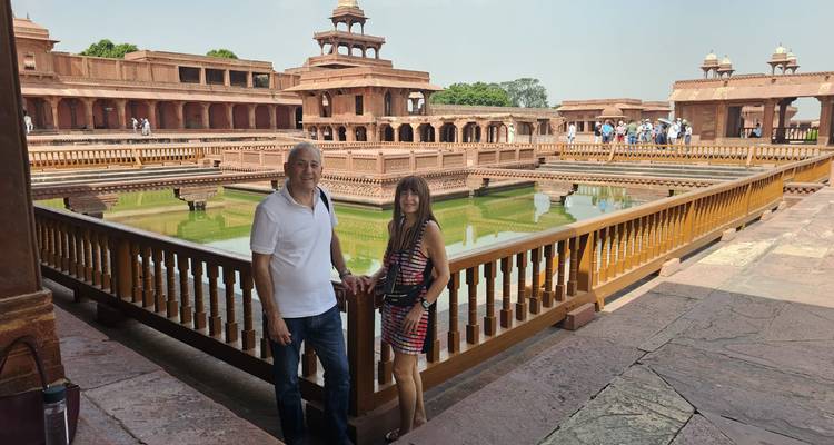 Pareja posando junto a una piscina histórica.