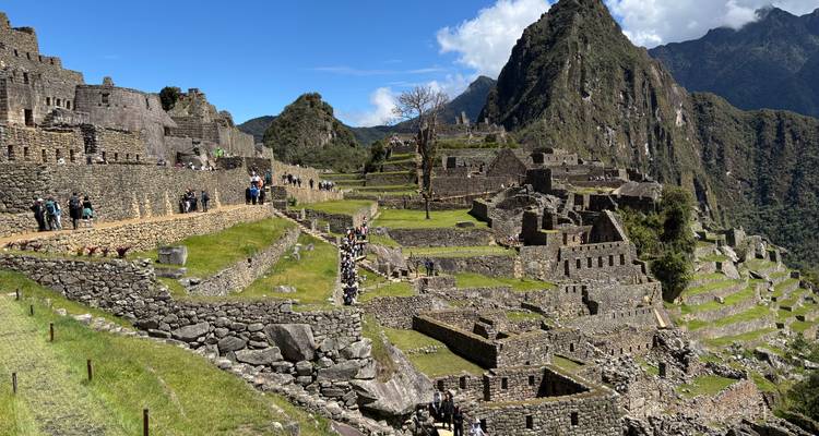 Ikonische archäologische Stätte mit terrassierten Ruinen und Bergen.