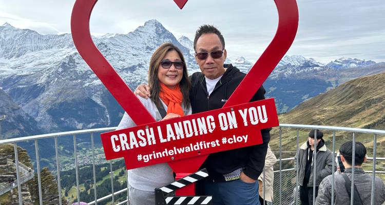 Couple avec un cadre en forme de cœur et des montagnes en arrière-plan.