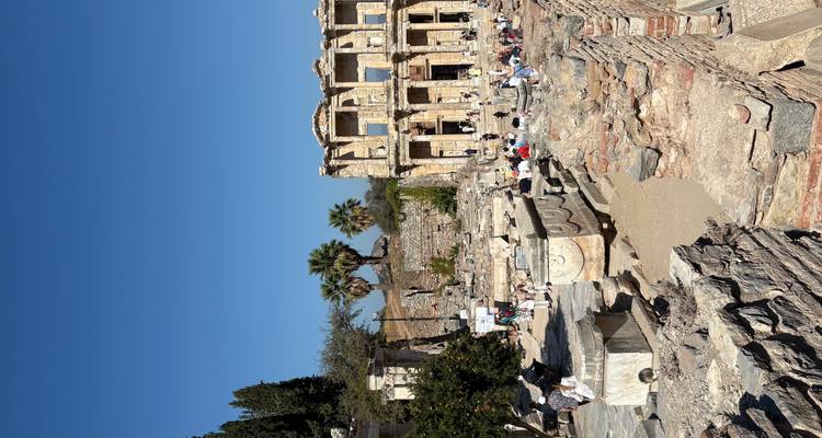 Touristes visitant les ruines antiques avec des colonnes et des structures historiques.