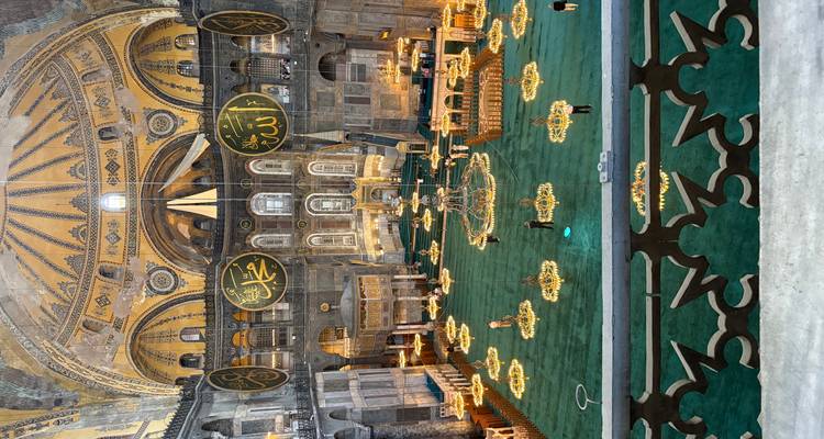 Vue intérieure d'une grande mosquée avec des décorations ornées et des lustres.