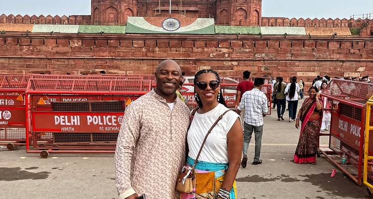 Couple standing in front of a historic fort with an Indian flag.