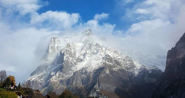 Sommet enneigé avec des nuages qui se dissipent.