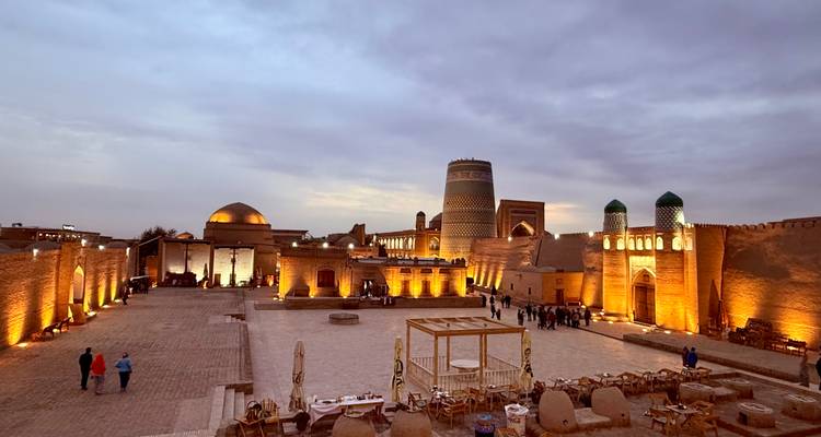 Place historique avec bâtiments illuminés et visiteurs.