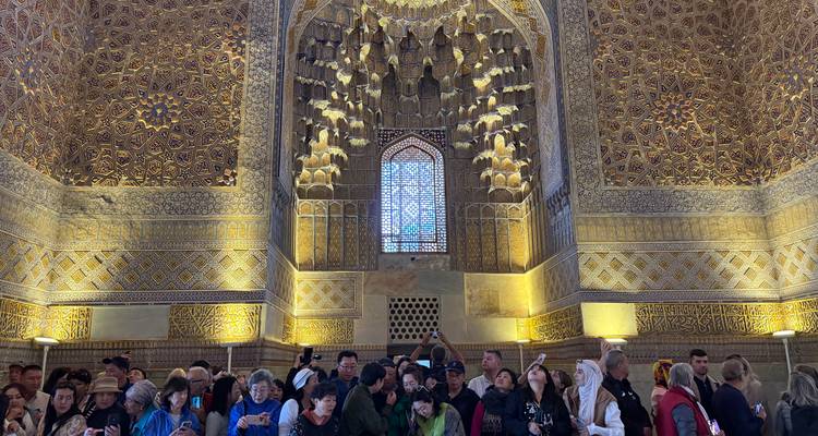 Des touristes regardant un intérieur au design complexe avec de hauts plafonds.