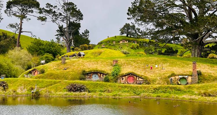 Paisaje del pueblo de Hobbiton con puertas coloridas.