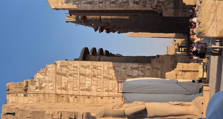 Ancient temple with carvings and tourists exploring.
