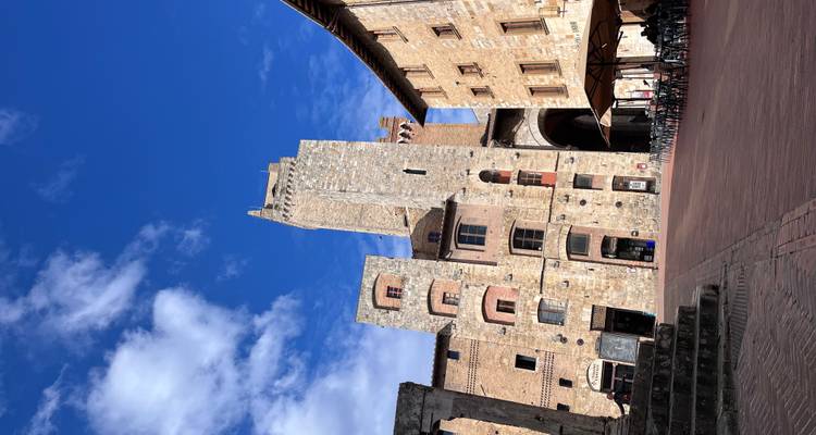 Stone tower in a town square with blue sky.
