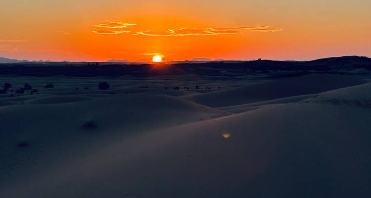 Sunset over sand dunes in the desert.