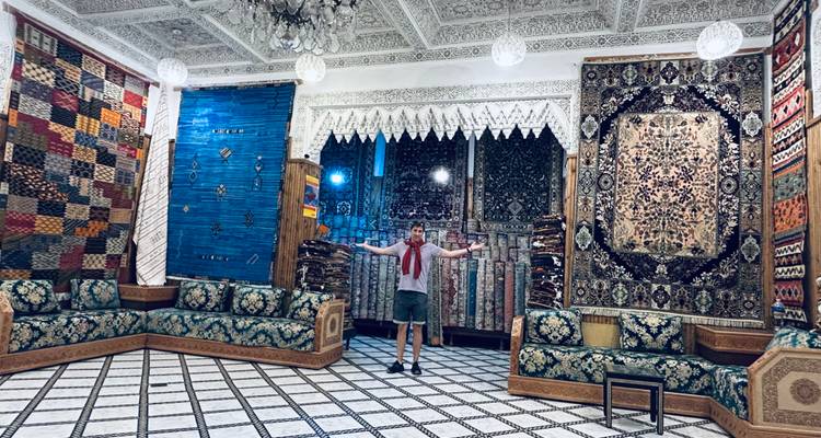 Person in a room with colorful carpets on the walls.