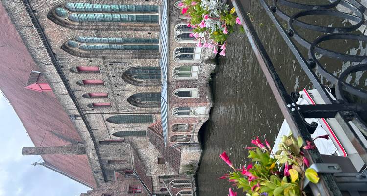 Une vue pittoresque de rivière avec des bâtiments historiques et des fleurs colorées.