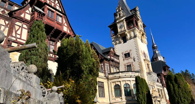 Bâtiment historique avec des façades ornementées et des tours sous un ciel bleu éclatant.