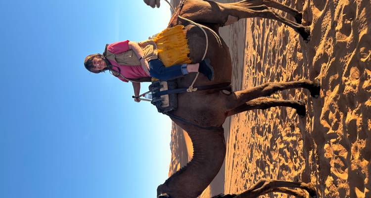 Woman riding a camel in the desert.