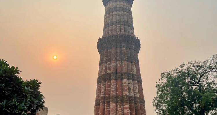Qutub Minar in New Delhi with the sun setting.