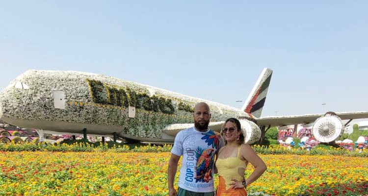 Zwei Menschen stehen vor einem mit Blumen bedeckten Flugzeug.