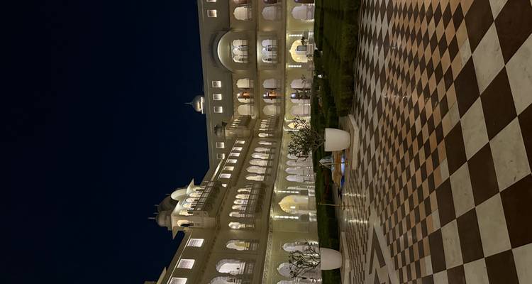Night view of a grand architectural building with lit arches.
